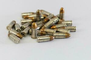 pilha do dourado 9mm pistola balas em uma branco fundo foto
