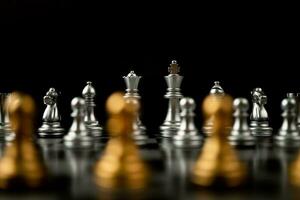 peão de xadrez dourado na frente de outro xadrez, o conceito de líder deve ter coragem e desafio na competição, liderança e visão de negócios para uma vitória em jogos de negócios foto