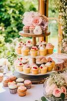 bolos de copo, bolos, scones e bolos e feriado decoração ao ar livre às a Inglês país estilo jardim, doce sobremesas para casamento, aniversário ou festa celebração, generativo ai foto