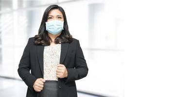 senhora asiática usando máscara nova normal no escritório para proteger o coronavírus covid-19 de infecção de segurança. foto