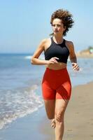 feliz jovem mulher desfrutando corrida exercício em de praia foto