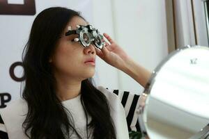 tailandês senhora vestindo Óculos dentro a clínica, mulher dentro ótico foto
