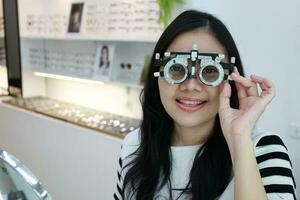 tailandês senhora vestindo Óculos dentro a clínica, mulher dentro ótico foto