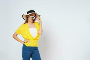 jovem mulher dentro oculos de sol vestindo, colorida roupas e Sol chapéu, isolado sobre branco background.lifestyle verão conceito. foto