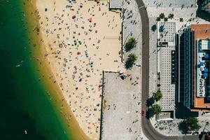 topo baixa zangão Visão do ribeira de praia dentro cascais, Portugal em uma verão dia com muitos pessoas em a de praia foto