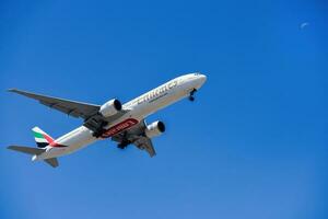 eua Sediada ar companhia Emirados com aeronave boeing 777-300er Aproximando para terra às Lisboa internacional aeroporto contra azul céu foto