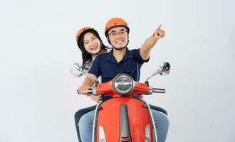 uma casal vestindo capacetes e equitação uma moto foto