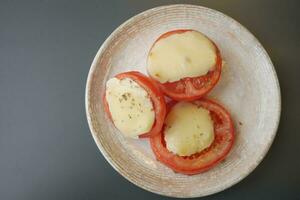 tomates recheado com queijo a partir de a forno foto