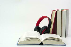 a fones de ouvido colocada em topo do a forrado acima livros. conhecimento, Aprendendo e Educação conceito. foto