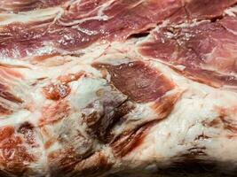 fresco todo peça do carne de porco pescoço em uma de madeira cozinha borda. peça do porco carne fechar acima foto