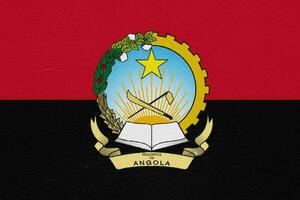 bandeira e casaco do braços do república do Angola em uma texturizado fundo. conceito colagem. foto