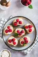 doce bruschettas com coalhada queijo e framboesas em uma prato topo e vertical Visão foto