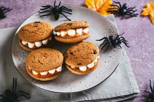 dia das Bruxas guloseimas biscoitos com marshmallow dentes em uma prato e aranhas foto