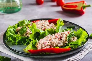 enlatado atum salada com legumes em alface folhas em uma prato foto