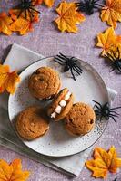 dia das Bruxas guloseimas biscoitos com marshmallow dentes em uma prato e aranhas topo e vertical Visão foto