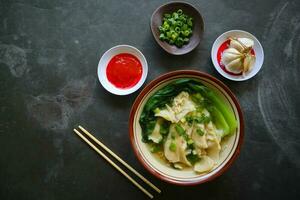 Wonton sopa ou angústia ou dumplings sopa e vegetal. Wonton é tradicional chinês Comida do picado carne embrulhado dentro farinha folhas foto