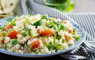 tradicional libanês salada tabule. cuscuz com salsinha, tomate, pepino, limão e Oliva óleo. meio Oriental cozinha. foto