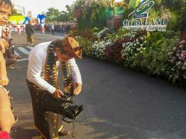 uma cameraman filmando a Surabaya aniversário celebração parada. Surabaia, Indonésia - poderia, 2023 foto