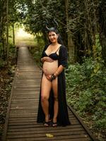 grávida mulher posando dentro natureza foto
