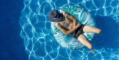 homem natação em nadar anel dentro a piscina. pessoa natação dentro a piscina. cristal água. Claro água superfície dentro água piscina. natação dentro a piscina em verão feriados. foto