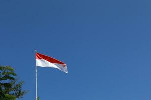 17 agosto 1945, indonésio bandeira contra céu fundo. independência dia conceito foto