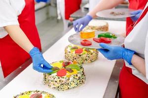 decoração de bolos na esteira de uma fábrica de confeitaria. foto