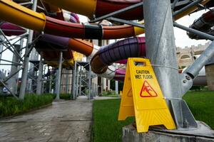 Cuidado molhado chão placa em água deslizar dentro aqua parque. segurança conceito. foto