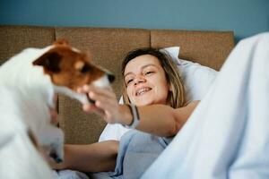 mulher dormindo dentro cama e jogar com dela cachorro foto