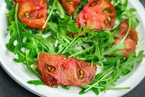 vermelho tomate salada Rúcula saudável refeição Comida lanche em a mesa cópia de espaço Comida fundo rústico topo Visão foto