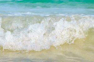 a mar ondas bater a arenoso praia, a mar é lindo, cristal Claro esmeralda.fechar acima foto