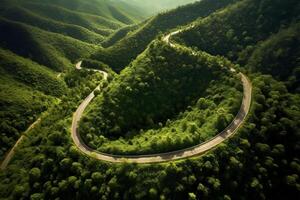 aéreo Visão do a enrolamento estrada através a verde floresta dentro verão foto