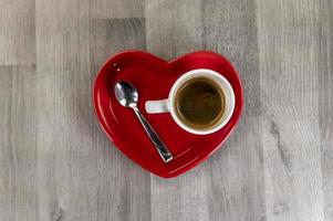 uma xícara de café com um pires em forma de coração
