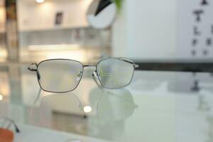 óculos estão colocada em a mesa dentro a oftalmologista. foto