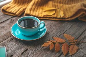 uma copo do quente café em a outono fundo. chá e outono folhas em uma de madeira fundo. cópia de espaço. foto