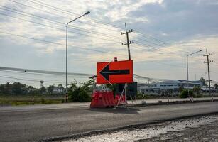 uma Visão do a superfície do uma Novo Preto asfalto estrada com sinais e laranja barricadas. foto