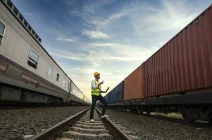 engenheiro inspeciona recipiente trem do transporte companhia distribuição e transporte do bens de trilho uma recipiente trem passagem através a industrial área foto