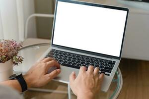 mão usando computador portátil e digitando em teclado com brincar do em branco tela. foto