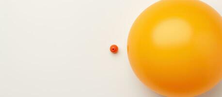 foto do uma vibrante laranja balão em repouso em uma limpar \ limpo branco mesa com cópia de espaço