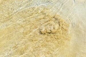 pequenas mini ondas de água no oceano de praia com areia méxico. foto