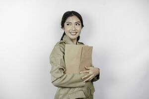 um jovem e belo trabalhador asiático com uniforme marrom trazendo documento. pns indonésio. foto