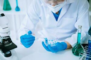 cientista misturando líquidos químicos no laboratório de química. pesquisador trabalhando no laboratório químico foto