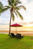 guarda-chuva com cadeira com fundo de praia de mar e nascer do sol pela manhã