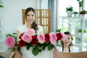 jovem ásia mulher florista trabalhando às flor comprar, ela é feliz e sorridente. entregar flores para clientes foto