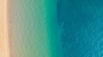 vista aérea da praia com sombra azul esmeralda água e ondas de espuma no mar tropical foto