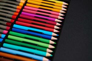multicolorido de madeira lápis. fechar-se. lápis para desenhando em uma Preto superfície foto