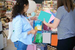 traseiro Visão do uma vendedora e cliente dentro criativo arte loja. grávida mulher compras para escola papelaria foto