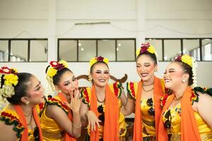 uma grupo do tradicional javanese dançarinos rindo juntos com ridículo rostos e cheio do alegria enquanto em etapa foto