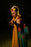 retrato do a indonésio dançarino com uma ouro cinto dançando graciosamente foto