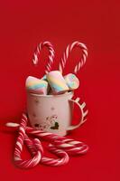 Natal composição com quente chocolate decorado com marshmellows e doce bengalas isolado sobre vermelho colori Backgroud com cópia de espaço para de Anúncios foto