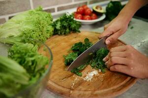 culinária. Comida e conceito do veganismo, vigor e saudável comendo - fechar acima do fêmea mão corte legumes e espinafre folhas para salada foto